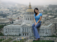 breasts giantess collage city mega clothed brunette smiling unknown_artist sitting looking_at_viewer sitting_on_building capital_building flags