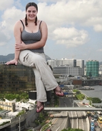 giantess collage city large_breasts clothed cleavage highway looking_at_viewer legs_crossed sitting_on_building