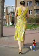 collage high_heels buildings dress walking shrunken_man sidewalk behind_view