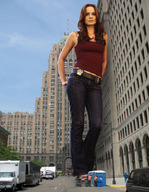breasts giantess collage city mega long_hair buildings jeans police vehicles leaning_against_building point_of_view from_below necklace road looking_at_viewer belt redish_hair police_officer