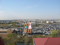 giantess collage blonde clothed high_heels wonderslug dress muscles legs giantesses vehicles clothing parking_lot behind_view distant_city