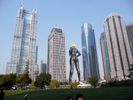 giantess collage city blonde park wonderslug grass standing reflection skyscrapers sky black_suit behind_view latex_suit