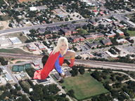 giantess collage blonde destruction wonderslug boots supergirl houses fist aerial_view cape looking_at_viewer