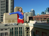 giantess collage city mega blonde skirt wonderslug supergirl sky cape looking_at_viewer between_buildings dc_comics