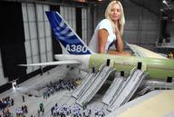 giantess collage blonde unknown_artist sitting airplane indoors crowds jenni_czech hangar looking_at_tiny