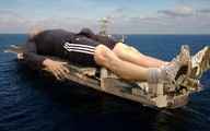 water socks lying_down bulge shorts sneakers outdoors aircraft_carrier long_sleeved_shirt