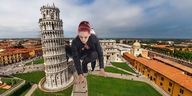 giantess cleavage buildings red_hair leggings grass crouching combat_boots hairband leaning_tower_of_pisa