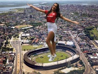 giantess collage city long_hair clothed skirt buildings shoes brunette stadium standing river shirt looking_at_viewer zebos2003 emilly_araújo
