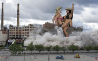 breasts giantess collage city mega blonde black_hair swimsuit destruction cleavage lesbians giantesses factory cowboy_hat sitting_on_building