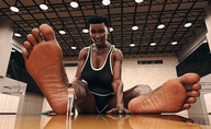 growth feet black_hair clothed toes barefoot cleavage soles low_angle smiling short_hair shrunken_woman looking_down dark_skin indoors gym basketball_court looking_at_tiny digital_render bare_legs lutherlittle
