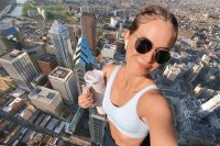 breasts giantess collage city bridge buildings brunette short_hair unknown_artist shorts sunglasses river top jogging source_needed selfie earphone bare_midriff