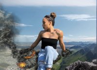 breasts giantess collage city mega destruction jeans brunette unknown_artist sitting mountains smoke tattoo earrings top source_needed ripped_jeans hair_bun
