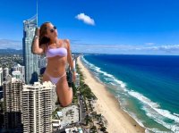 breasts giantess collage city mega swimsuit beach ocean buildings brunette unknown_artist kneeling watch sunglasses source_needed
