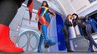 breasts black_hair large_breasts butt cleavage gloves red_hair short_hair boots unaware shrunken_woman mask pants avengers dark_skin thighs indoors fist belt jumpsuit bracelet running_away laboratory looking_at_tiny black_widow digital_render ms_marvel prank marvel_comics scarlet_witch captain_marvel kamala_khan the_wasp carol_danvers celton