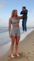 mini_giantess ai_art elevated_humor giantess blonde long_hair clothed beach handheld jeans domination shorts standing hoodie sports_bra