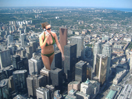 giantess city swimsuit cleavage brunette navel walking sunglasses skyscrapers cellphone